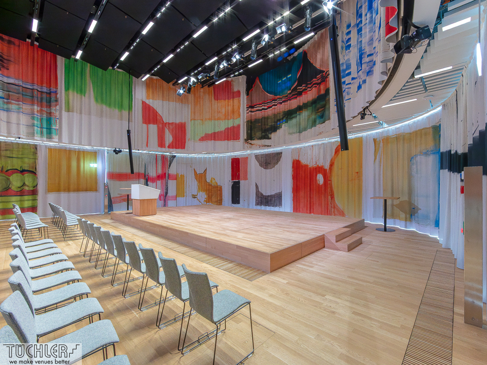 Architektur, Akustik und Kunst vereint: Digital bedruckte Kunstvorhänge mit TT2‑Schiene und T‑LOK‑Antrieb im Neubau in Basel